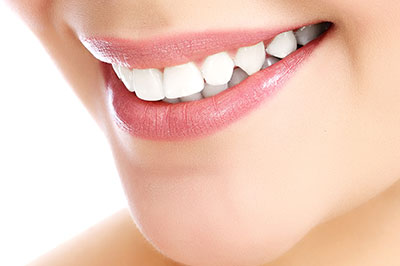 The image shows a close-up of a person s face with a focus on their teeth, which appear bright and well-maintained.