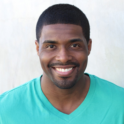 An older couple, a man and a woman, are embracing each other with smiles on their faces.