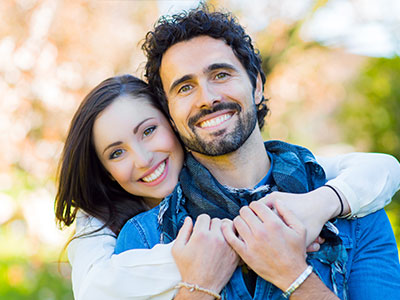 A man and a woman are embracing each other in a warm hug.